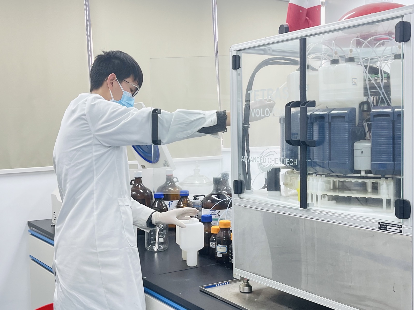 Scientist operating peptide synthesis equipment in the RCMT laboratory